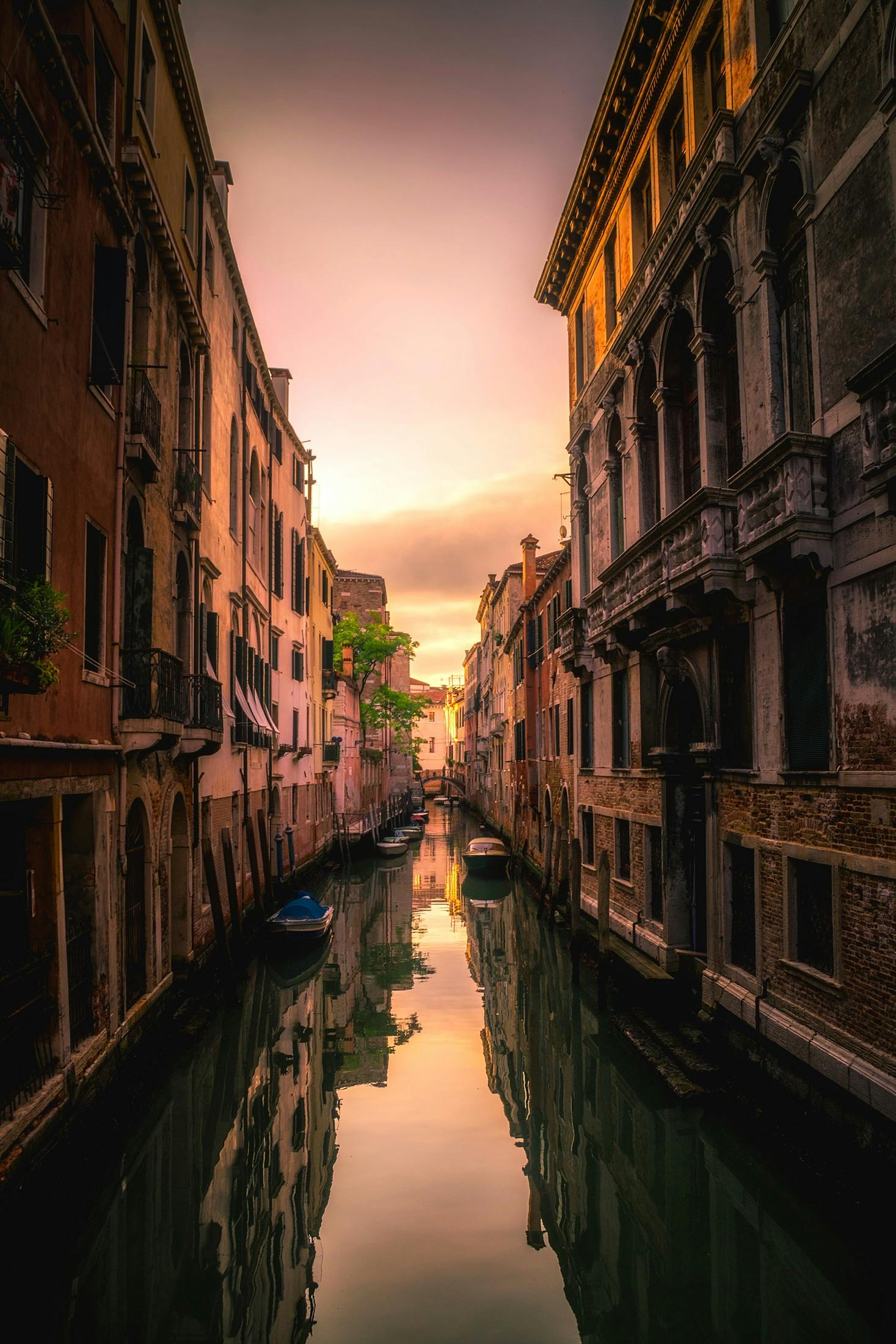 Captivating sunset view reflected on a serene Venetian canal amidst historic architecture.