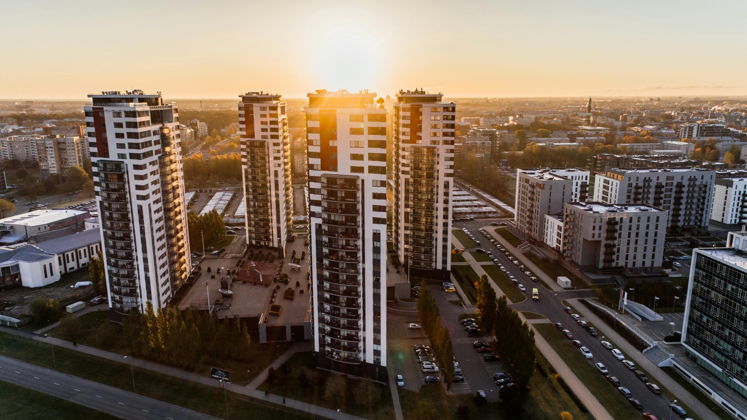 Captivating high-rise buildings silhouetted by a setting sun in a bustling cityscape.